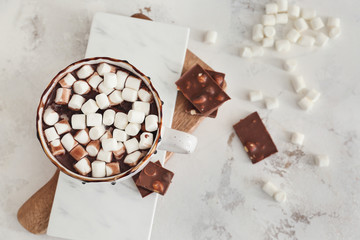 Cup of hot chocolate with marshmallows on light background