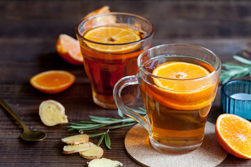 Hot citrus tea on wood table, close-up. Healthy warming drinks with lemon orange and honey.