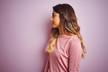 Obraz premium Young beautiful woman wearing a sweater over pink isolated background looking to side, relax profile pose with natural face with confident smile.