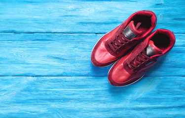 Pair of red sports shoes on a wooden floor background with copy space.