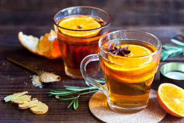 Hot tea with orange on wood background, close-up