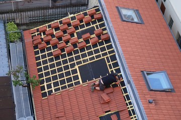 Couvreur posant des tuiles sur le toit d'une maison © Florence Piot