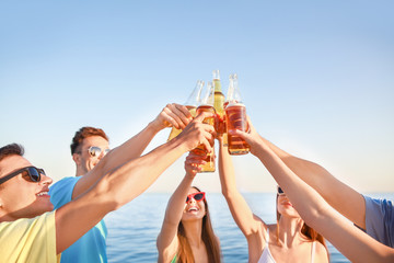 Friends drinking beer on sea beach