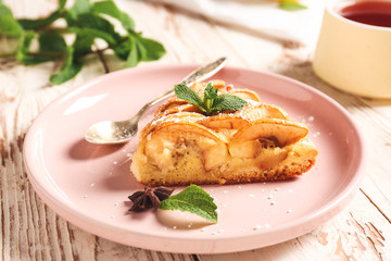 Plate with piece of sweet apple pie on wooden table