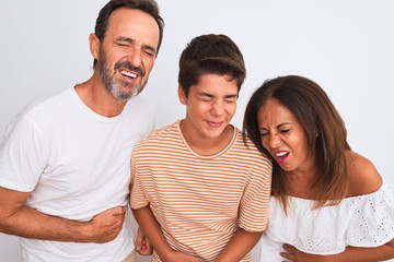 Family of three, mother, father and son standing over white isolated background with hand on...