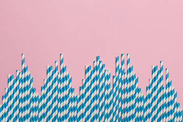 Striped coctail straws on pink background. Birthday party celebration abstract fashion baby shower concept. Minimalist pastel flatlay style.