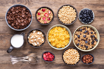 Breakfast cereals in bowls on rustic wooden table, top view