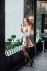 Woman in shopping time. Happy blonde woman with shopping bags enjoying in shopping. Consumerism, shopping, lifestyle concept