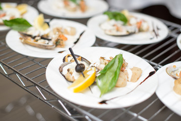 Scallops, creatively arranged food on a white restaurant plate.