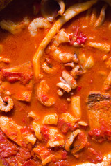 fish soup on an metallic pan, top view, natural direct light with shadow