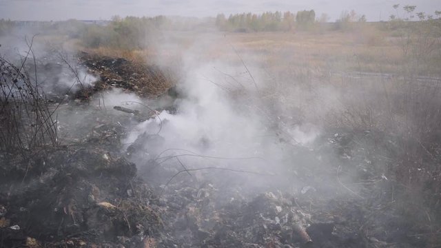Burning garbage dump pollutes the environment. Strong wind rises toxic smoke of burning garbage into the air and spreads it on long distance. Burning landfill, waste, burning trash in the city.