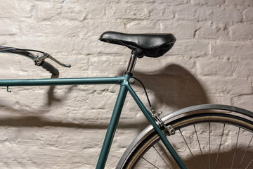 Fototapeta na wymiar Detail of a bicycle at white brick wall