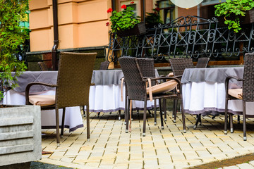 Fototapeta na wymiar Chairs and tables in a cozy street cafe