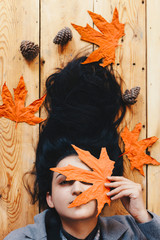 Autumn woman. Fall season concept. A portrait of lying on wooden floor woman