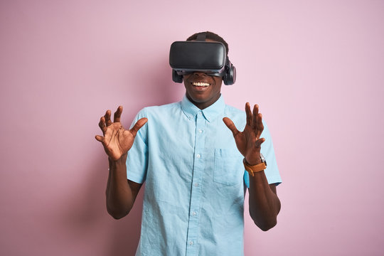 Young african american man playing virtual reality game using goggles