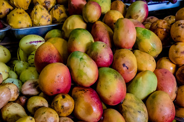 Naklejka na ściany i meble Stack of mangoes for sale in an Ecuadorian market
