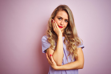 Fototapeta premium Young beautiful woman wearing purple t-shirt standing over pink isolated background thinking looking tired and bored with depression problems with crossed arms.