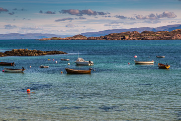 Fototapeta na wymiar Isle of Mull as Seen Across the Sea with Boats in the harbor, from Iona, Scotland