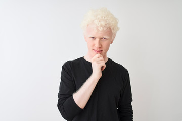Young albino blond man wearing black t-shirt standing over isolated white background looking...