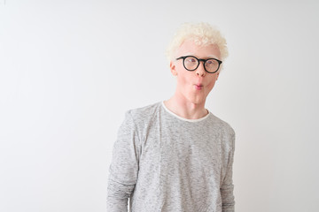 Young albino blond man wearing striped t-shirt and glasses over isolated white background making...