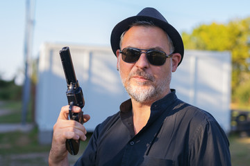 Portrait of a man holding a gun replica