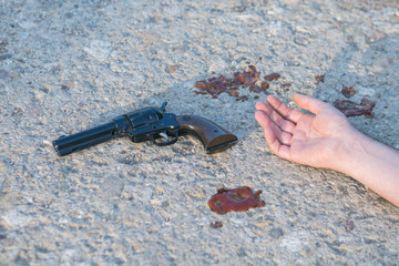 gun and hand at murder scene