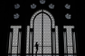 Black and white female silhouette, window with ornaments, Hassan II mosque in Casablanca, Morocco.    