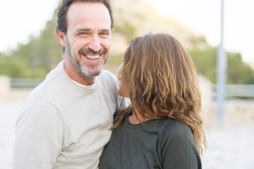 Romantic couple smiling and cuddling on a sunny day