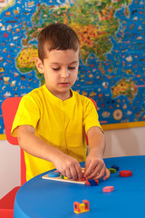 Kid playing with wooden colorful puzzle, education concept