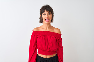 Young beautiful woman wearing red summer t-shirt standing over isolated white background sticking tongue out happy with funny expression. Emotion concept.