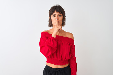 Young beautiful woman wearing red summer t-shirt standing over isolated white background asking to be quiet with finger on lips. Silence and secret concept.