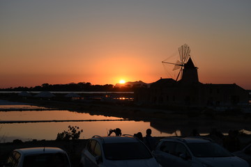 Fototapeta na wymiar Sunset in Saline of Marsala with Windmill, Stagnone, Trapani, Sicilia.