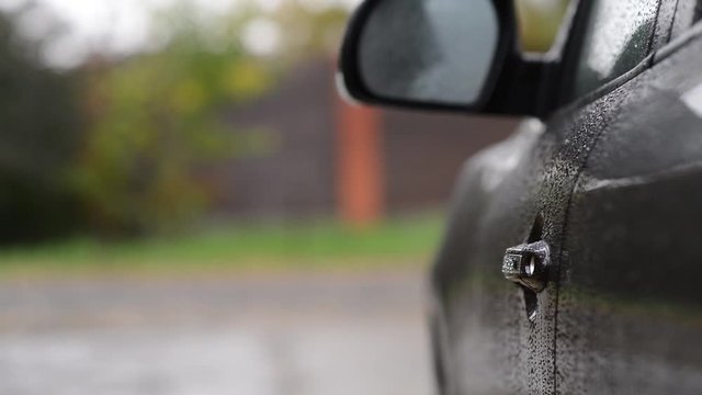 the girl opens the door of the SUV, gets behind the wheel and leaves the village. Selective focus, no face