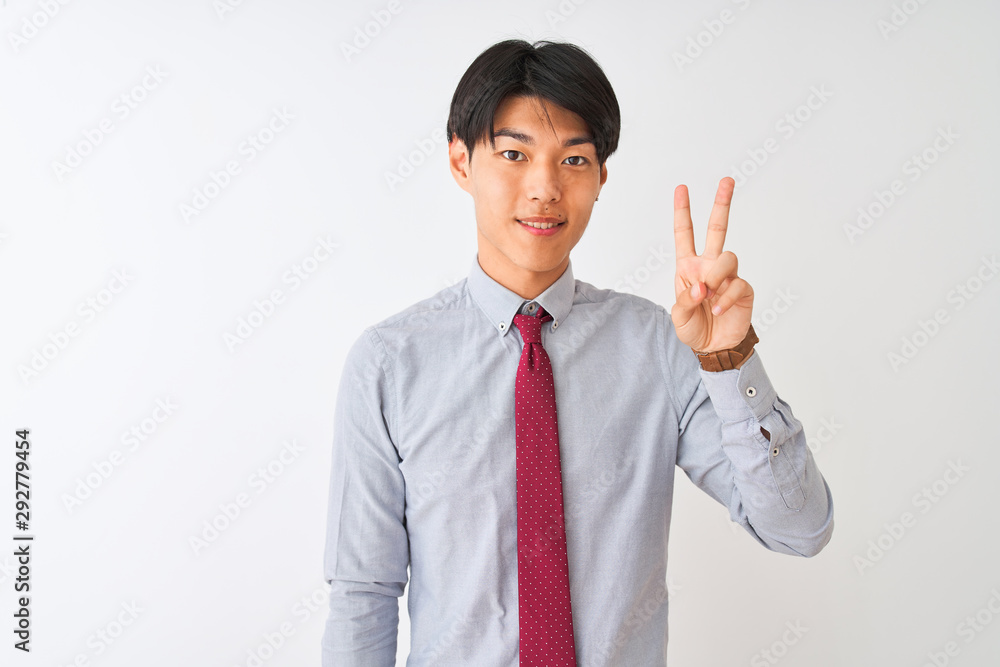 Wall mural chinese businessman wearing elegant tie standing over isolated white background showing and pointing