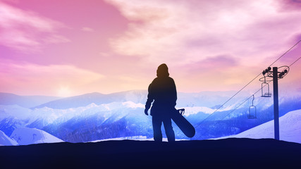 Snowboarder on the background of a bright sunset in the mountains.