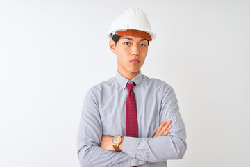 Chinese architect man wearing tie and helmet standing over isolated white background skeptic and...