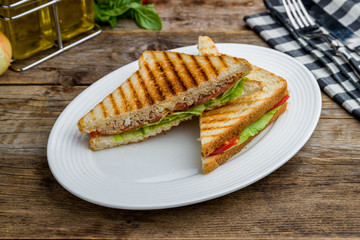 sandwich with tuna and vegetables on wooden table