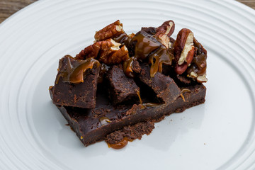 Brownie with nuts on white plate
