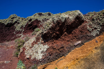 Red, orange and black stratified cliffs in Santorini Island