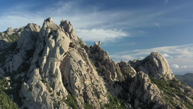 View from above, aerial view of some stunning granite mountains surrounded by a rich and green vegetation in San Pantaleo, Sardinia, Italy.