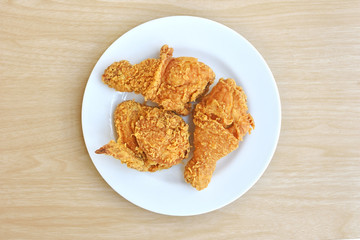 Crispy fried chicken in white plate on a wooden table