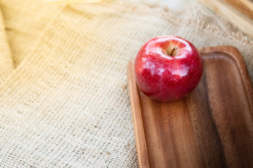 An apple on the wood plate and bag - photo