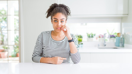 Beautiful african american woman with afro hair wearing casual striped sweater mouth and lips shut...