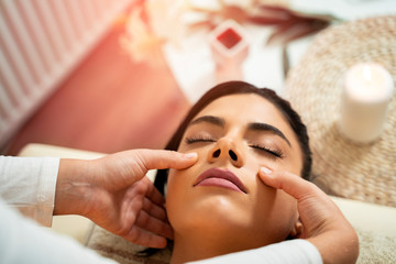 Closeup of pretty woman having face massage (anti wrinkle )