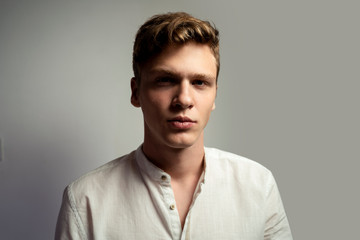 Closeup shot of teenager in white shirt, looking at camera
