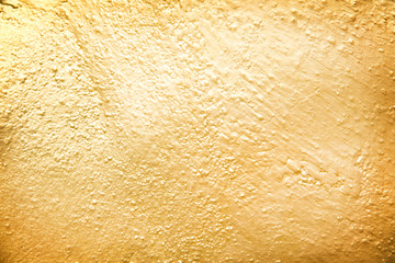 Gold paint on concrete wall abstract texture in rough seamless patterns for background