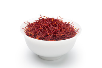 Dried saffron in a white ceramic cup. Isolated on white background.
