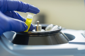Close up of hand scientist is loading a sample to mini centrifuge in laboratory, Concept science and technology, Science background