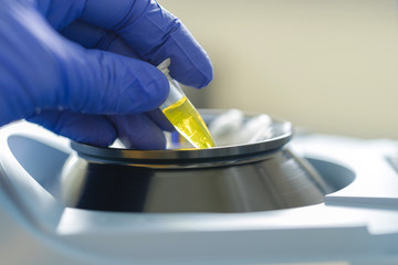 Close up of hand scientist is loading a sample to mini centrifuge in laboratory, Concept science and technology, Science background