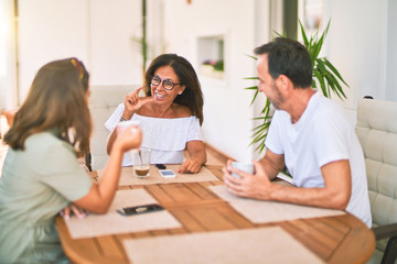 Obraz premium Beautiful family sitting on terrace drinking cup of coffee speaking and smiling